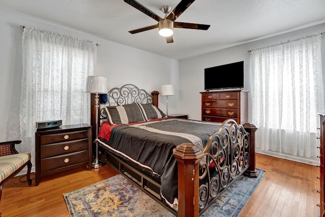 bedroom with light hardwood / wood-style floors and ceiling fan