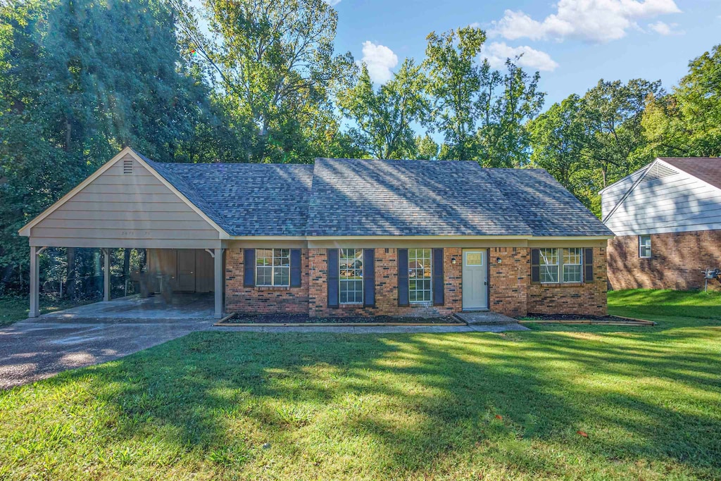 view of front of home with a front yard and a carport