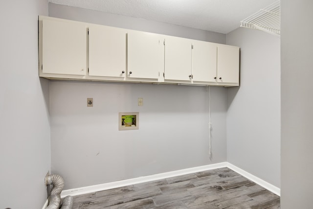 clothes washing area featuring hookup for a washing machine, hookup for an electric dryer, a textured ceiling, cabinets, and hardwood / wood-style floors