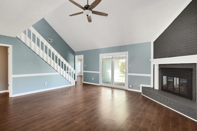 unfurnished living room with ceiling fan, a textured ceiling, high vaulted ceiling, a fireplace, and dark hardwood / wood-style flooring