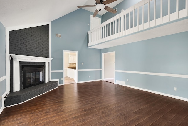 unfurnished living room featuring ceiling fan, a fireplace, dark hardwood / wood-style flooring, and high vaulted ceiling