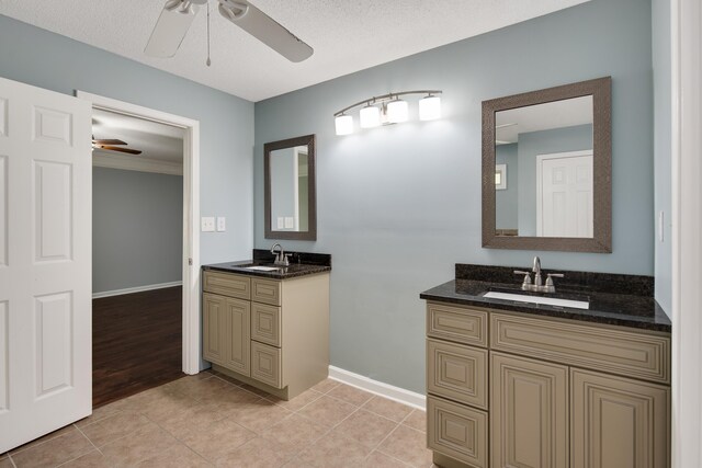 bathroom with ceiling fan, vanity, a textured ceiling, and hardwood / wood-style flooring