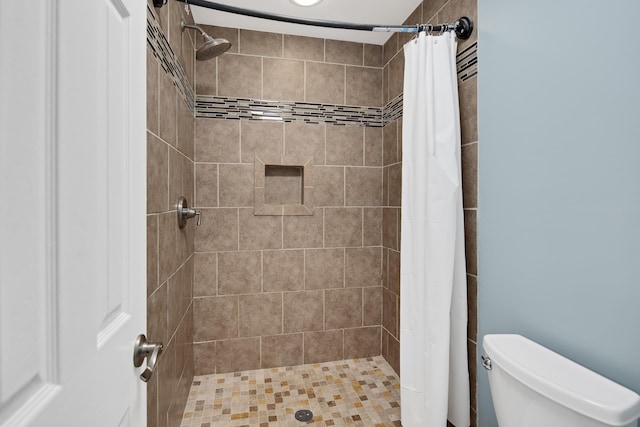 bathroom with a shower with shower curtain and toilet