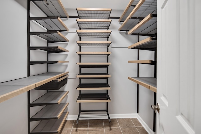 walk in closet featuring dark tile patterned floors