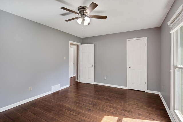 unfurnished bedroom featuring ceiling fan and dark hardwood / wood-style floors