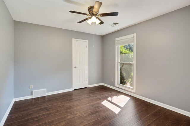 empty room featuring ceiling fan and dark wood-type flooring