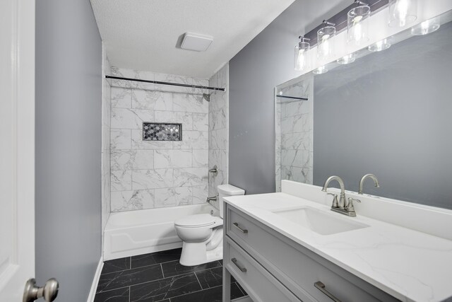 full bathroom with a textured ceiling, tiled shower / bath, vanity, and toilet