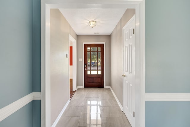 doorway to outside featuring a textured ceiling