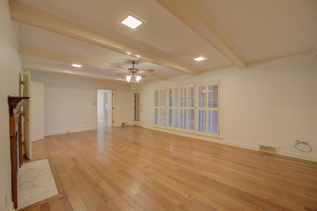 unfurnished living room with light wood-type flooring, beam ceiling, and ceiling fan