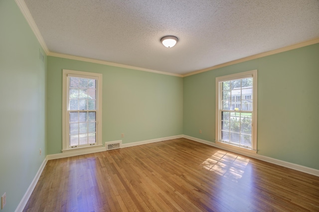 spare room featuring a textured ceiling, wood-type flooring, and ornamental molding