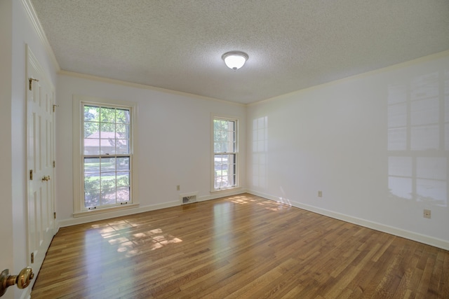 spare room with wood-type flooring, a textured ceiling, and crown molding