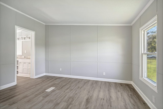 empty room featuring crown molding and light hardwood / wood-style flooring