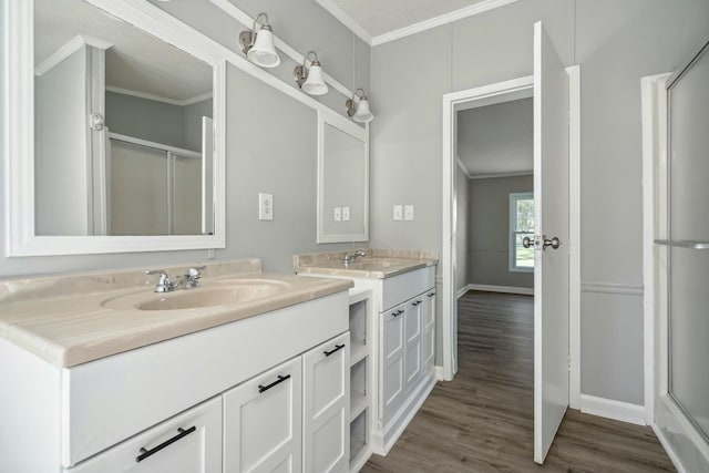 bathroom with ornamental molding, vanity, hardwood / wood-style flooring, and an enclosed shower