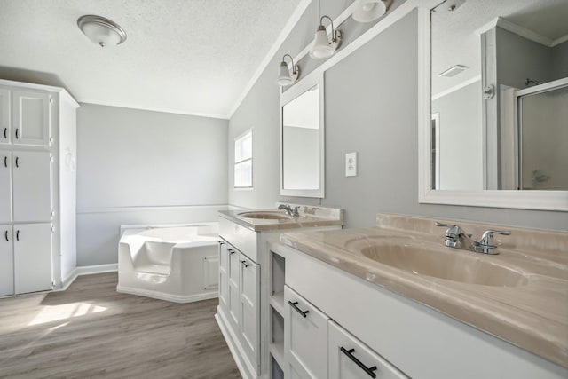 bathroom with shower with separate bathtub, a textured ceiling, hardwood / wood-style flooring, and vanity