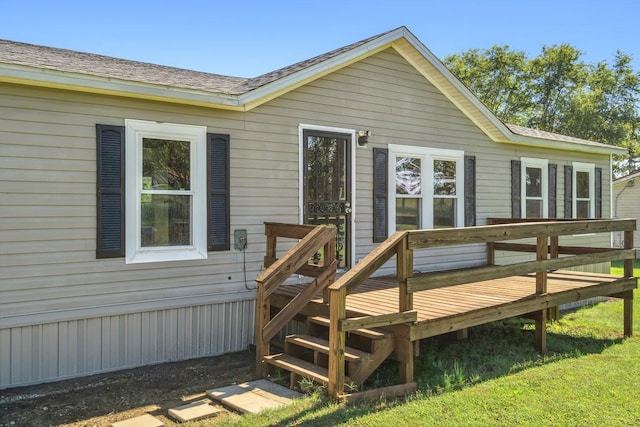 rear view of house featuring a lawn and a wooden deck