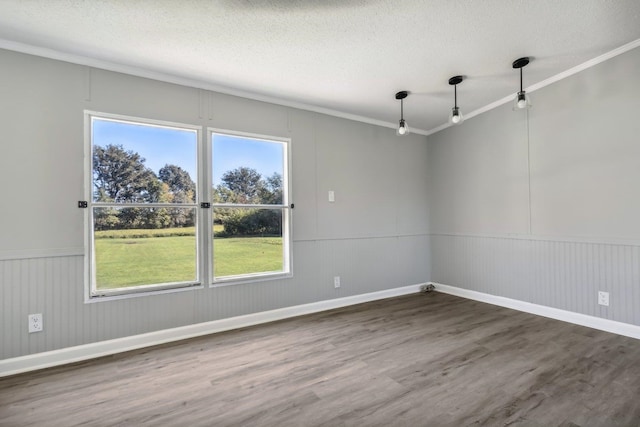 spare room featuring a textured ceiling, ornamental molding, and dark hardwood / wood-style flooring