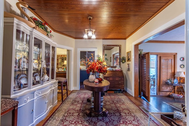 foyer featuring ornamental molding, wood ceiling, a chandelier, and dark wood-type flooring