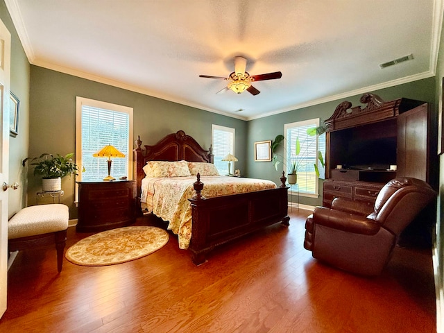 bedroom featuring multiple windows, hardwood / wood-style floors, and ceiling fan