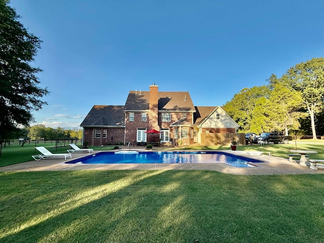 view of swimming pool featuring a diving board, a yard, and a patio area