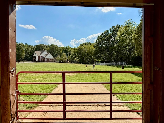 view of gate featuring a rural view and a yard