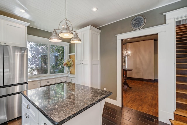 kitchen with a center island, dark hardwood / wood-style floors, white cabinetry, decorative light fixtures, and stainless steel fridge