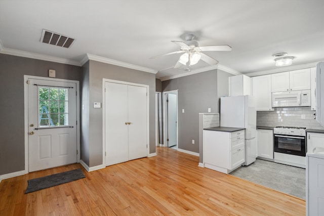 kitchen featuring light wood-type flooring, ornamental molding, white appliances, and white cabinetry