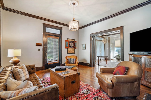 living room with hardwood / wood-style flooring, crown molding, a notable chandelier, and a wealth of natural light