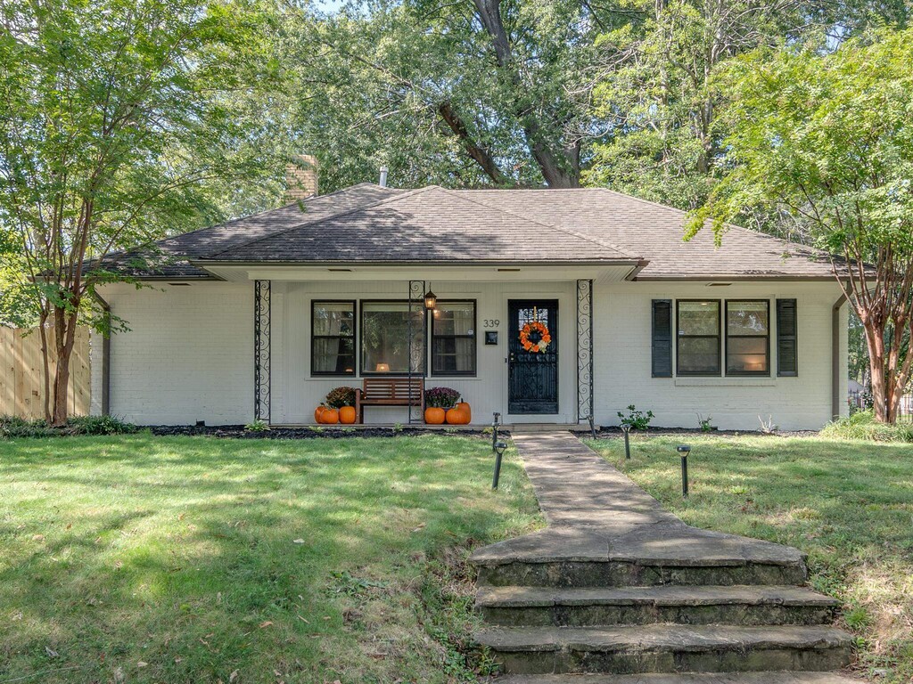 ranch-style house with a porch and a front lawn