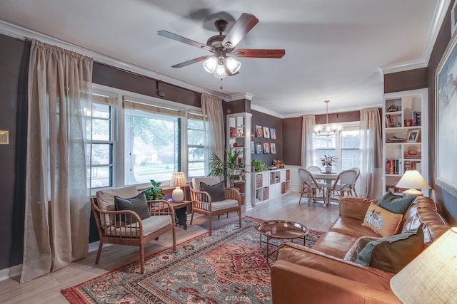 living room featuring light hardwood / wood-style flooring, a wealth of natural light, ceiling fan with notable chandelier, and ornamental molding