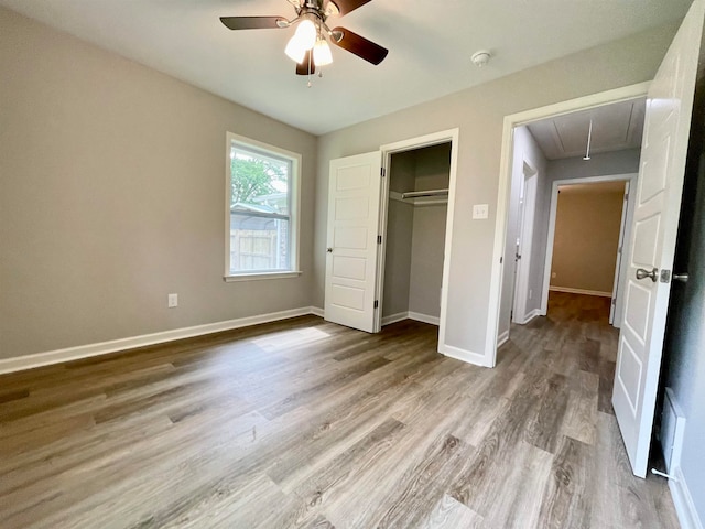 unfurnished bedroom featuring light hardwood / wood-style floors, ceiling fan, and a closet