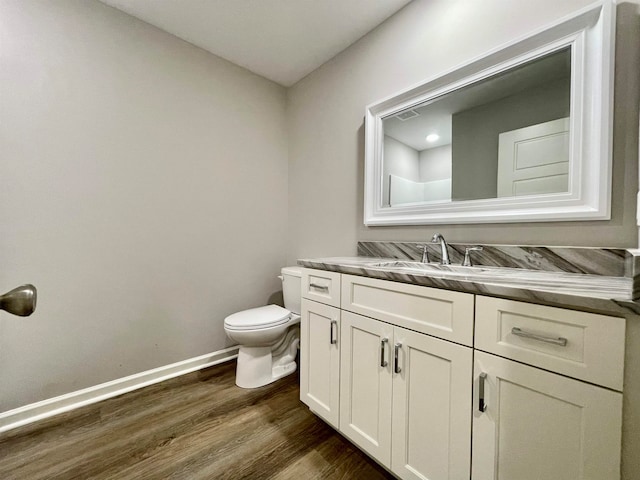 bathroom featuring wood-type flooring, vanity, and toilet