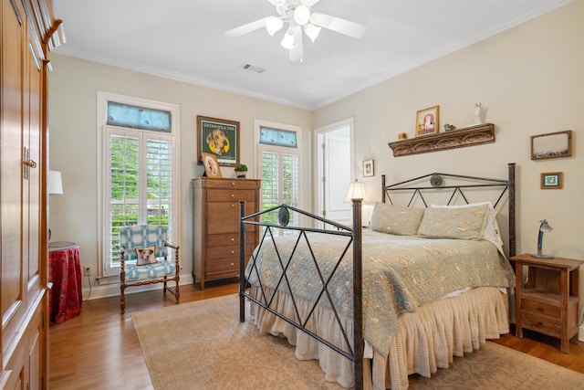 bedroom with wood-type flooring, ceiling fan, and crown molding