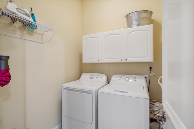 laundry area with cabinets and washer and clothes dryer