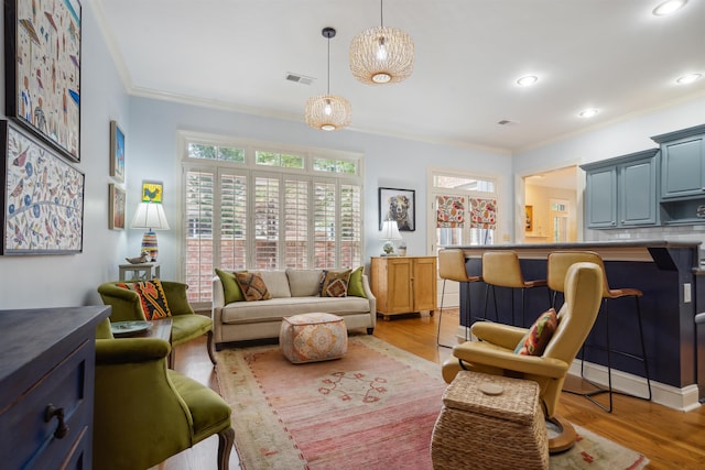 living room featuring ornamental molding and light hardwood / wood-style floors