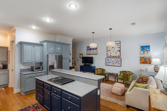 kitchen with light wood-type flooring, a kitchen island, ornamental molding, blue cabinetry, and stainless steel fridge