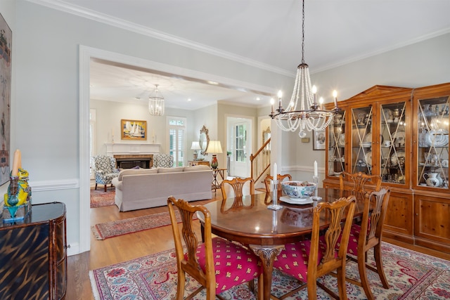 dining space featuring ornamental molding, an inviting chandelier, and hardwood / wood-style floors