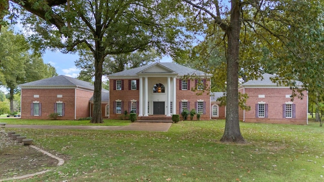 neoclassical / greek revival house featuring a front yard