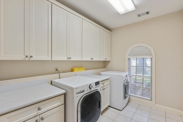 laundry area with cabinets, washing machine and clothes dryer, and light tile patterned floors