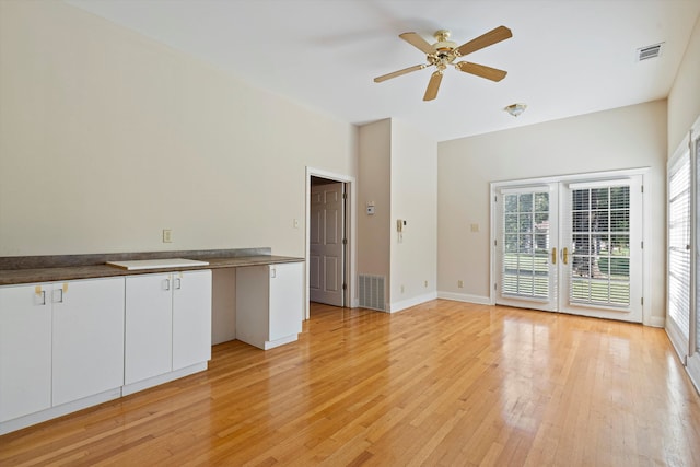 unfurnished living room featuring french doors, light wood-type flooring, and ceiling fan