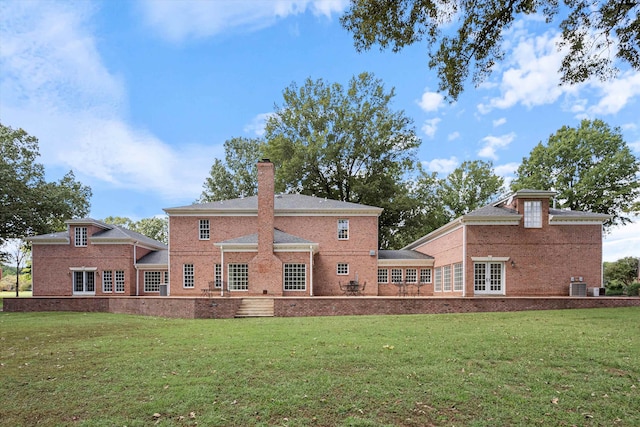 rear view of property with central AC unit, a lawn, and a patio