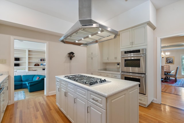 kitchen with light wood-type flooring, island exhaust hood, a kitchen island, and stainless steel appliances