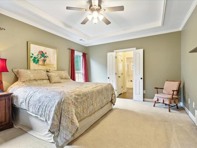 bedroom featuring a raised ceiling, crown molding, carpet flooring, ceiling fan, and ensuite bathroom