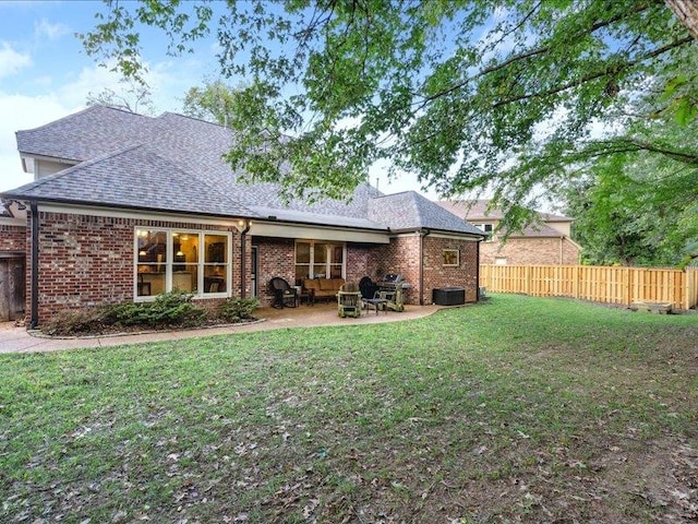 rear view of house with a lawn and a patio