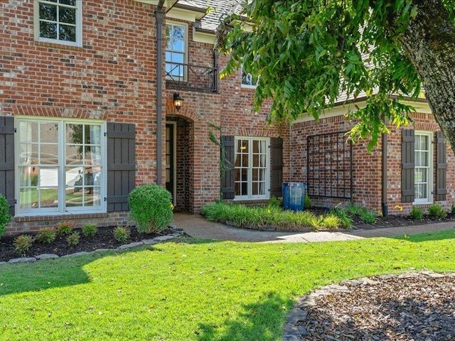 view of exterior entry with a yard