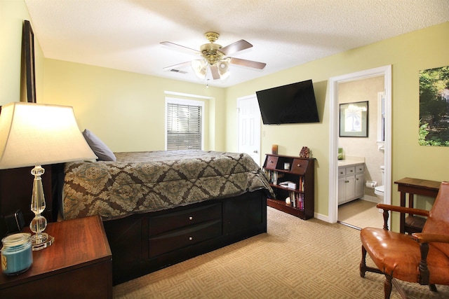 carpeted bedroom featuring a textured ceiling, ceiling fan, and ensuite bathroom