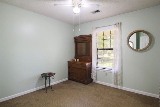 carpeted spare room with ceiling fan and a textured ceiling