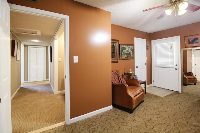 carpeted entryway featuring a textured ceiling and ceiling fan