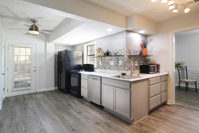 kitchen with gray cabinets, appliances with stainless steel finishes, and hardwood / wood-style floors