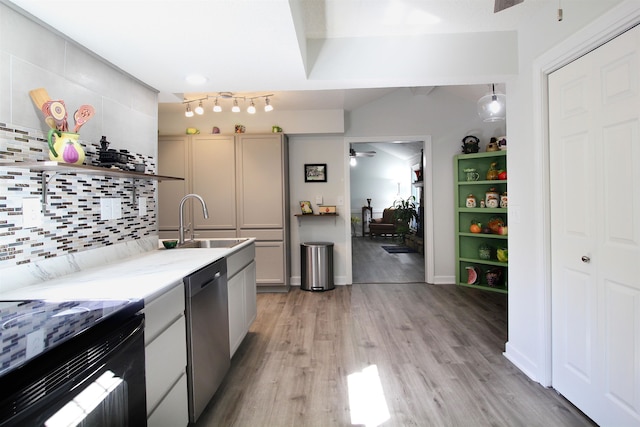 kitchen featuring light wood-type flooring, tasteful backsplash, sink, black range with electric cooktop, and stainless steel dishwasher