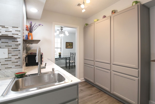 kitchen with gray cabinetry, a textured ceiling, and sink